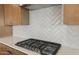 Gas cooktop with herringbone tile backsplash in modern kitchen at 7163 W Oberlin Way, Peoria, AZ 85383