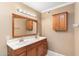 Bathroom with double vanity, wood cabinets, and a large mirror at 7714 E Mariposa Dr, Scottsdale, AZ 85251