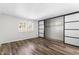 Bedroom with wood-look floors and open closet with sliding doors at 7714 E Mariposa Dr, Scottsdale, AZ 85251