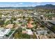 Expansive aerial view of a neighborhood with lush landscaping, swimming pools, and stunning mountain views in the distance at 9504 E Sunnyside Dr, Scottsdale, AZ 85260