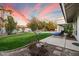 Backyard with lush lawn, pool, shade trees and comfortable lounge chairs on the rear patio at 9504 E Sunnyside Dr, Scottsdale, AZ 85260