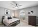 Bedroom with modern decor, arched window, ceiling fan and neutral walls at 9504 E Sunnyside Dr, Scottsdale, AZ 85260