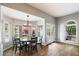 Sunlit dining room featuring a chandelier, wood floors, and large windows showcasing a vibrant outdoor view at 9504 E Sunnyside Dr, Scottsdale, AZ 85260