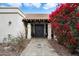 Home featuring a covered front entry and decorative plants enhancing the walkway at 9504 E Sunnyside Dr, Scottsdale, AZ 85260