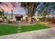 Inviting front exterior with a well-maintained lawn, mature trees, and a charming walkway at 9504 E Sunnyside Dr, Scottsdale, AZ 85260