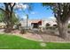 Charming single-story home featuring desert landscaping, mature trees, and a secure gated entrance at 9504 E Sunnyside Dr, Scottsdale, AZ 85260