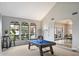 Well-lit game room featuring a pool table, arched windows, and an open floor plan at 9504 E Sunnyside Dr, Scottsdale, AZ 85260