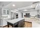 Modern kitchen with white cabinets, stainless steel appliances, and a large center island with a white countertop at 9504 E Sunnyside Dr, Scottsdale, AZ 85260