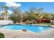 Beautiful pool with mature landscaping, rock feature and surrounding seating areas at 9504 E Sunnyside Dr, Scottsdale, AZ 85260