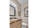 A powder room featuring a beige vanity with granite countertop and framed mirror at 10040 E Happy Valley Rd # 300, Scottsdale, AZ 85255
