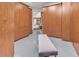 Large walk-in closet with wood cabinets, a bench, and access to the bedroom at 10040 E Happy Valley Rd # 300, Scottsdale, AZ 85255