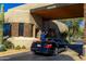 Luxury car parked at a desert home entrance featuring wood beams and stone accents at 10040 E Happy Valley Rd # 300, Scottsdale, AZ 85255
