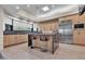 Modern kitchen with island seating, stainless steel appliances, and stylish light fixtures at 10040 E Happy Valley Rd # 300, Scottsdale, AZ 85255