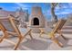Inviting backyard space with an outdoor fireplace and lounge chairs, ideal for relaxing evenings at 10040 E Happy Valley Rd # 300, Scottsdale, AZ 85255