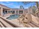 Scenic backyard showcasing the pool, outdoor fireplace, and beautiful desert landscaping for ultimate relaxation at 10040 E Happy Valley Rd # 300, Scottsdale, AZ 85255