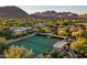 Aerial view of a private tennis court surrounded by lush greenery and desert landscape at 10040 E Happy Valley Rd # 300, Scottsdale, AZ 85255