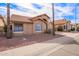 Tan house with tile roof, two palm trees, and rock landscaping at 10729 W Laurelwood Ln, Avondale, AZ 85392