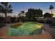 Lush backyard pool area featuring a waterfall feature, desert landscaping, and lounge seating at 12743 W Highland Ave, Litchfield Park, AZ 85340