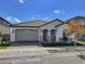 Single-story home with gray garage door and landscaping at 15787 W Mariposa Grande --, Surprise, AZ 85387