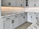 Gray kitchen cabinets with granite countertops and tile backsplash at 15787 W Mariposa Grande --, Surprise, AZ 85387