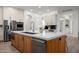 Open concept kitchen with a central island featuring a marble countertop, prep sink, and stainless steel appliances at 1723 W Brianna Rd, Phoenix, AZ 85085