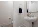 Clean and modern powder room with a pedestal sink, stylish mirror, and neutral tones at 1723 W Brianna Rd, Phoenix, AZ 85085