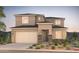 Two-story house with beige exterior, stone accents, and landscaped front yard at 18172 E Tiffany Dr, Queen Creek, AZ 85142