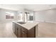 Kitchen island with undermount sink and view into an open floorplan and large windows at 18180 E Tiffany Dr, Queen Creek, AZ 85142