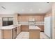Well-lit kitchen with stainless steel dishwasher, breakfast bar, and tiled flooring at 19850 N 110Th Ln, Peoria, AZ 85373