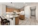 Well-lit kitchen featuring tile flooring, wood cabinets, white appliances and an island with space for seating at 19850 N 110Th Ln, Peoria, AZ 85373