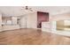 Open-concept living room with laminated wood floors and an adjacent kitchen view at 19850 N 110Th Ln, Peoria, AZ 85373
