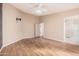 Bright main bedroom with laminated wood floors and modern ceiling fan at 19850 N 110Th Ln, Peoria, AZ 85373