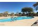 Refreshing outdoor community pool with patio seating and umbrella-covered tables at 19850 N 110Th Ln, Peoria, AZ 85373