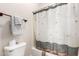 Well-lit bathroom features a toilet, shower with decorative curtain, and towel rack, offering practicality at 20914 W Cora Vis, Buckeye, AZ 85396