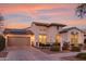 Charming two-story home with a front yard, two-car garage, and solar panels at dusk at 20914 W Cora Vis, Buckeye, AZ 85396