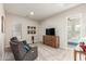 Cozy living room features comfortable seating, a TV, and a view into a sunny bedroom, ideal for relaxing at 20914 W Cora Vis, Buckeye, AZ 85396