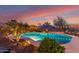 Backyard pool with palm trees, outdoor lighting, and chairs at dusk at 20914 W Cora Vis, Buckeye, AZ 85396