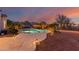 Serene backyard pool oasis featuring desert landscaping and a colorful sunset at 20914 W Cora Vis, Buckeye, AZ 85396