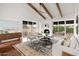 Bright living room featuring wood beams, fireplace, and access to a patio at 2527 N Miller Rd, Scottsdale, AZ 85257