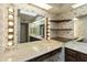 A bathroom has a large mirror with Hollywood lighting and wallpaper at 26622 S Beech Creek Dr, Sun Lakes, AZ 85248