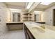 A bathroom has two sinks, large mirrors with Hollywood lighting and wallpaper at 26622 S Beech Creek Dr, Sun Lakes, AZ 85248