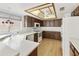 Traditional kitchen featuring wood cabinets, white appliances, and a light-filled tray ceiling with fan at 26622 S Beech Creek Dr, Sun Lakes, AZ 85248