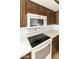 Close-up of the kitchen featuring white appliances and dark wood cabinetry with ample counter space at 26622 S Beech Creek Dr, Sun Lakes, AZ 85248