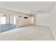 Living room with white carpet and white walls has a sliding glass door to a sun room at 26622 S Beech Creek Dr, Sun Lakes, AZ 85248
