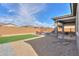 View of a backyard with gravel landscaping, artificial turf, patio, and red outdoor furniture at 346 E Tahiti E Dr, Casa Grande, AZ 85122