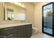 Stylish bathroom with gray cabinetry, marble countertops, and modern fixtures, with a view to the outside at 3643 E Coolidge St, Phoenix, AZ 85018