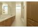 Bright bathroom features dual sinks, natural wood cabinets, a window, tub and walk-in shower at 3643 E Coolidge St, Phoenix, AZ 85018