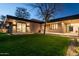 Beautiful home exterior with a well-maintained lawn and modern design at twilight at 3643 E Coolidge St, Phoenix, AZ 85018