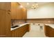 Laundry room with wood cabinetry, granite countertop, stainless steel sink, and tiled backsplash at 3643 E Coolidge St, Phoenix, AZ 85018