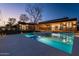 Backyard pool and spa with modern home featuring lush landscaping and fence at dusk at 3643 E Coolidge St, Phoenix, AZ 85018